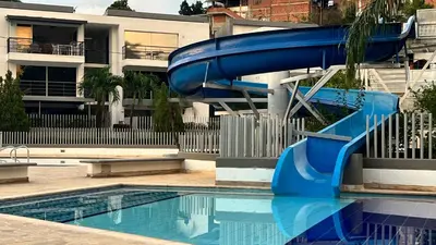 a blue water slide in a swimming pool at Hermoso Apartasol, cerca al Parque Principal, Piscinas, Aire acondicionado in Santa Fe de Antioquia