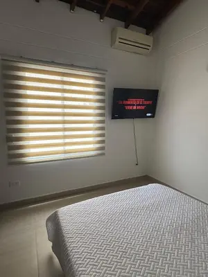 a bedroom with a bed and a television on the wall at Full apartment in Laureles in Medellín
