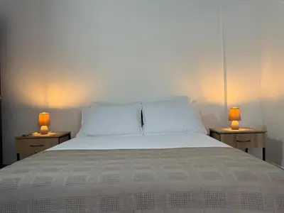 a bedroom with a bed with two lamps on two tables at Refugio en laureles in Medellín