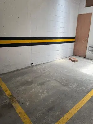 an empty parking garage with a door and a yellow stripe at Refugio en laureles in Medellín