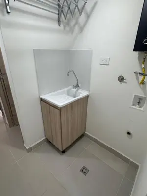 a white bathroom with a sink in a room at Apartamento balcón laureles estadio ED Milagros in Medellín