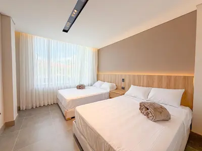 a hotel room with two beds and a window at Apartamento de lujo a 3 minutos del Aeropuerto JMC 102 in Rionegro