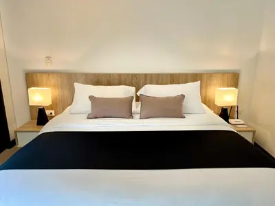 a bedroom with a large white bed with two pillows at Suites - Llanogrande in Rionegro