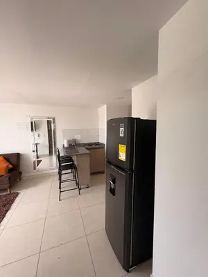 a kitchen with a black refrigerator in a room at Apartamento Urban Manizales Acogedor in Manizales