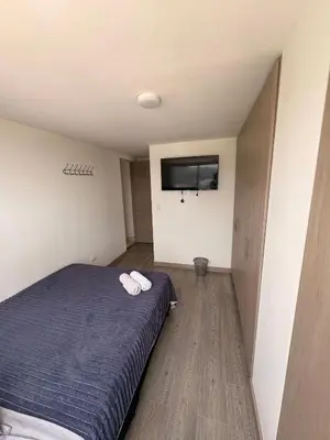 a bedroom with a bed and a flat screen tv at Apartamento Urban Manizales Acogedor in Manizales
