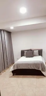 a bedroom with a bed in a white room at Cómodo apartamento por días in Manizales