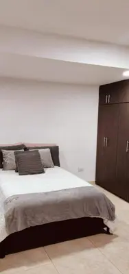a bedroom with a large bed and wooden cabinets at Cómodo apartamento por días in Manizales