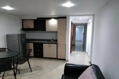 a kitchen and a living room with a table and chairs at Cómodo apartamento por días in Manizales
