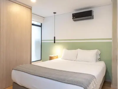a bedroom with a large white bed and a window at NOK Spectacular 3 BR w Balcony in Laureles Medellin in Medellín