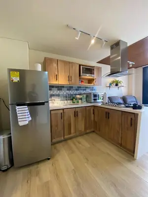 a kitchen with a stainless steel refrigerator and wooden cabinets at San Telmo Apartment with Jacuzzy in Guatapé