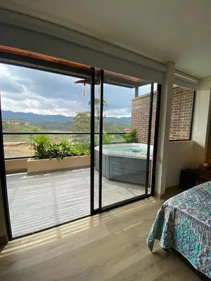 a bedroom with a sliding glass door to a balcony at San Telmo Apartment with Jacuzzy in Guatapé
