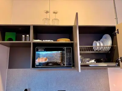 a microwave oven in a kitchen with plates and dishes at Estrena Apartamento, Avenida Santander, BREAK SUITES in Manizales