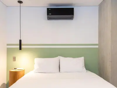 a bedroom with a white bed with a tv above it at NOK Fantastic 3 BR w Balcony in Laureles Medellin in Medellín