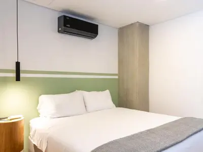 a bedroom with a bed with a tv on the wall at NOK Fantastic 3 BR w Balcony in Laureles Medellin in Medellín