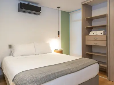 a bedroom with a bed and a tv on the wall at NOK Fancy 3BR Balcony in Laureles Medellin in Medellín