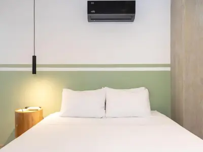 a bedroom with a white bed with a tv above it at NOK Stylish 3BR in Laureles MDE in Medellín
