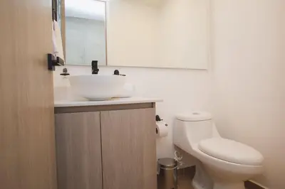 a bathroom with a sink and a toilet and a mirror at NOK Amazing with Balcony 3 BR in Laureles Medellin in Medellín