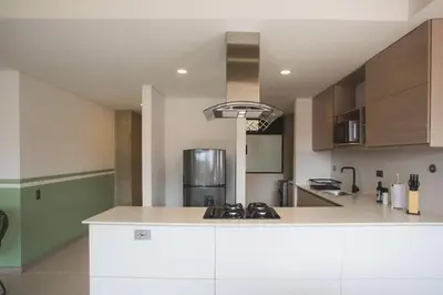a kitchen with a white counter top and wooden cabinets at NOK Amazing with Balcony 3 BR in Laureles Medellin in Medellín