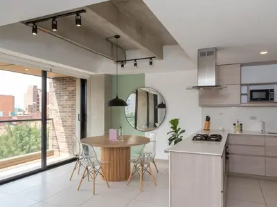 a kitchen with a table and chairs in a room at NOK Lovely 3 BR with Balcony in Laureles Medellin in Medellín
