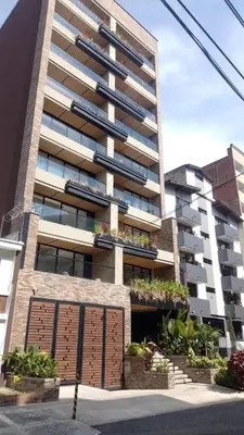 a large apartment building with a garage in front of it at NOK Lovely 3 BR with Balcony in Laureles Medellin in Medellín