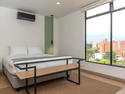 a bedroom with a bed and a large window at NOK Lovely 3 BR with Balcony in Laureles Medellin in Medellín
