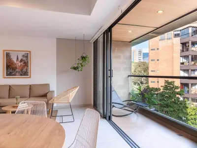a living room with a table and chairs and a couch at NOK Bright 3BR with terrace in Laureles Medellin in Medellín