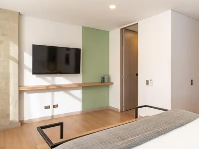 a bedroom with a flat screen tv on a wall at NOK Bright 3BR with terrace in Laureles Medellin in Medellín