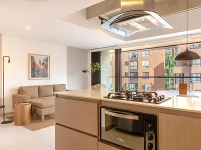 a kitchen and living room with a stove top oven at NOK Bright 3BR with terrace in Laureles Medellin in Medellín