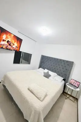 a bedroom with a bed and a picture on the wall at Apartamento cerca del estadio de Medellín in Medellín