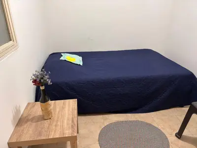 a bed with a blue blanket and a table with a vase of flowers at Minca in Medellín