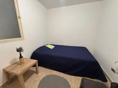 a small bedroom with a bed and a table at Minca in Medellín