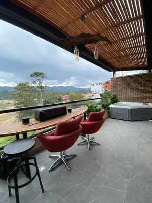 a patio with a table and chairs and a view at San Telmo Guatape Apto con Jacuzzy in Guatapé
