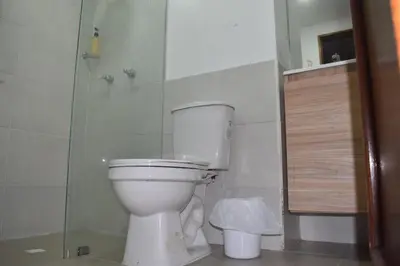 a bathroom with a white toilet and a shower at Habitación con cama nueva doble y balcón privado cerca del parque principal in La Ceja