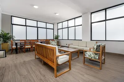 a waiting room with tables and chairs and windows at Ph volcana in Medellín