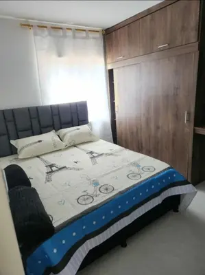a bedroom with a bed and a wooden cabinet at Apartamento el descanso in Medellín