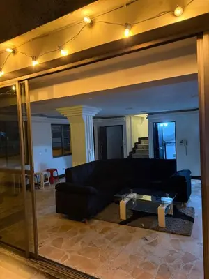 a living room with a black couch and a glass table at Lu alojamiento parque caldas in Manizales