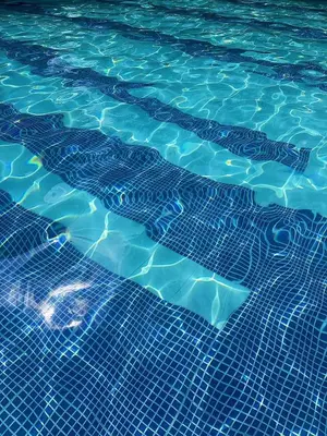 a swimming pool with a pattern of blue water at Cómoda Habitación condominio, wifi, piscina in Medellín