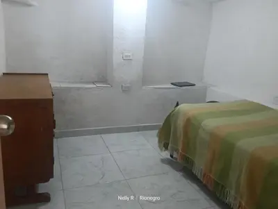 a room with two beds and a table and a window at Alojamiento Ríonegro in Rionegro
