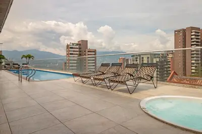 a balcony with chairs and a swimming pool on a building at Luxury Studio El Poblado City View 7th Floor in Medellín
