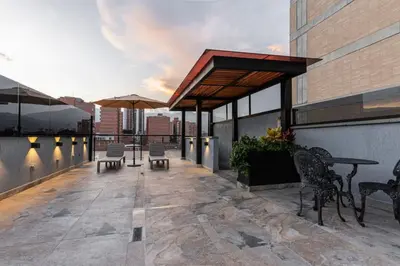 a patio with tables and chairs on a building at loft 72 holiday inn medellin in Medellín
