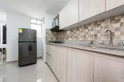 a large kitchen with a stainless steel refrigerator at 801-Acogedor Apto 2BR Parque Sabaneta in Sabaneta