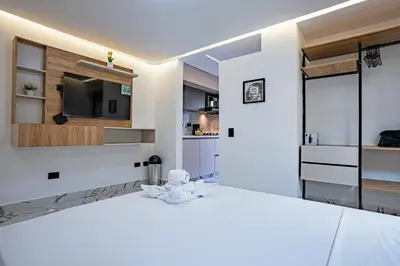 a white room with a large bed and a television at Exclusivo Urban Loft en Laureles in Medellín