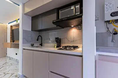 a kitchen with a stove and a microwave at Apartaloft exclusivo en laureles in Medellín