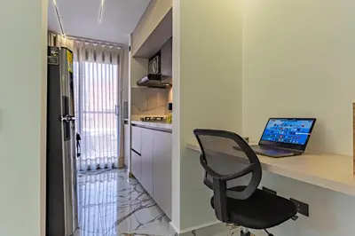 a desk with a laptop and a chair in a kitchen at Exclusivo Urban Loft en Laureles in Medellín