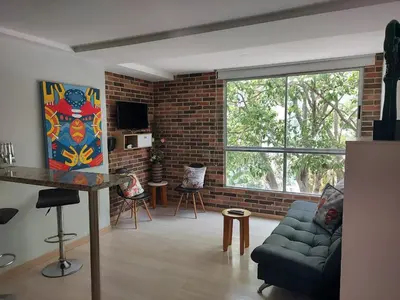 a living room with a couch and a brick wall at San Peter Family Suites in Medellín