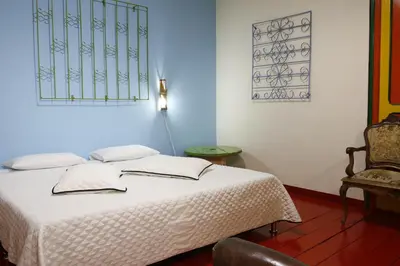 a bedroom with a bed and a chair at Golden Frog Manizales in Manizales
