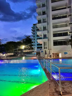 a swimming pool in front of a building at night at Hermoso Apartasol San Jeronimo in San Jerónimo