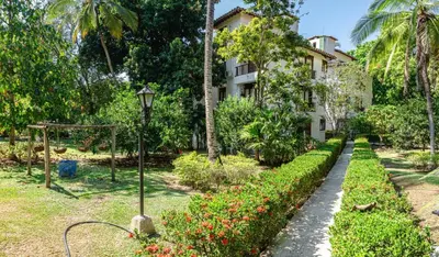 a garden in front of a building with flowers and a street light at ALDEA VACACIONAL LA FLORIDA Apto 103 Bloque 1 in Santa Fe de Antioquia
