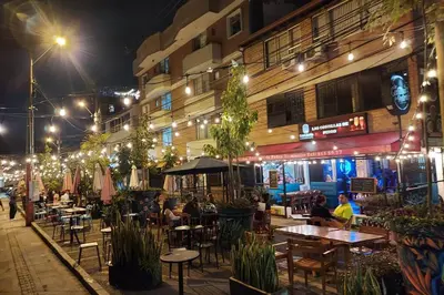 an outdoor restaurant with tables and chairs at night at Apartamento en Parque del Poblado in Medellín
