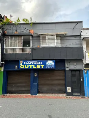 a building with two garage doors in front of it at Aparta estudio amoblado Medellin, San joaquin in Medellín
